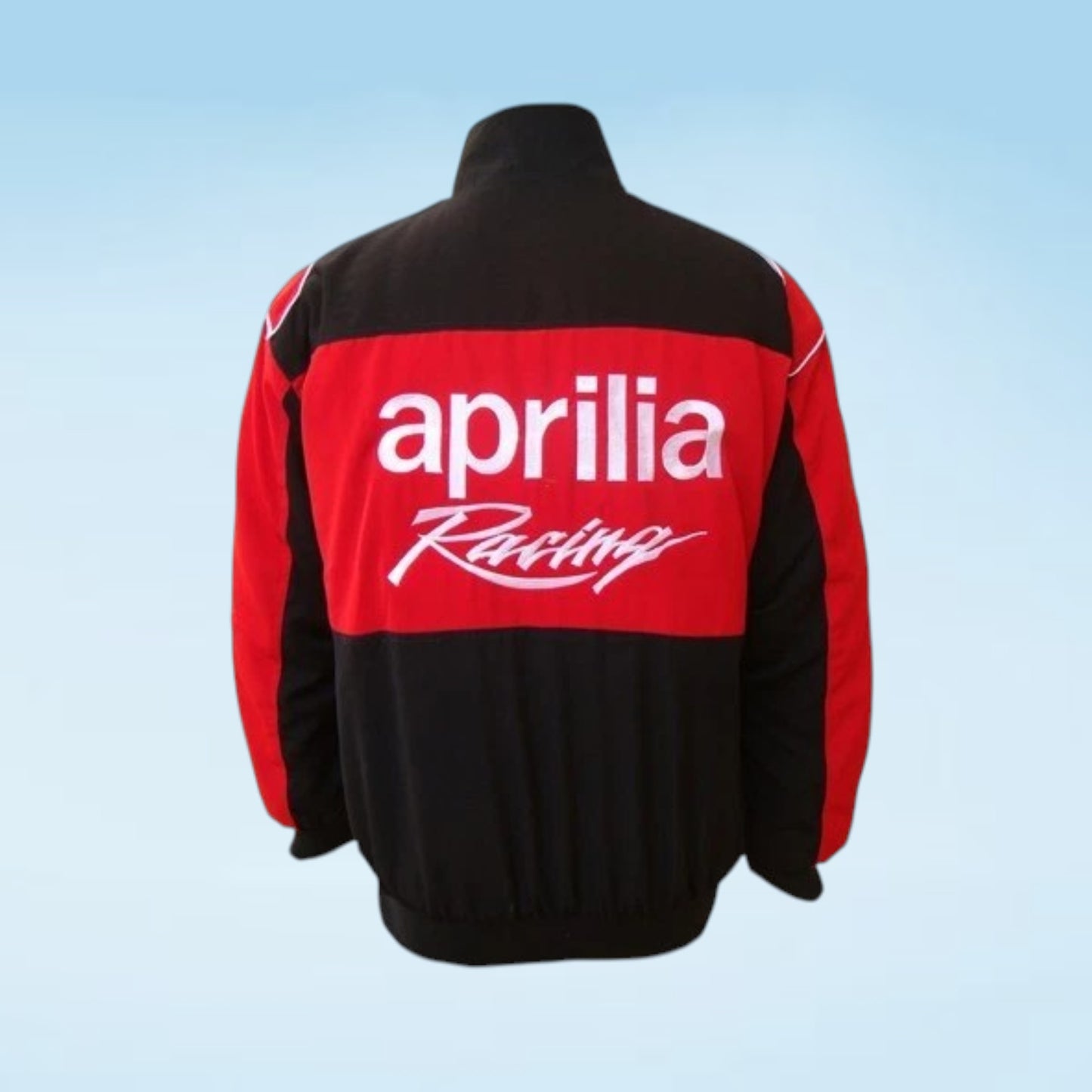 A black and red quarter-zip jacket shown from the back, featuring the white 'aprilia Racing' logo across the red panel, set against a light blue gradient background.