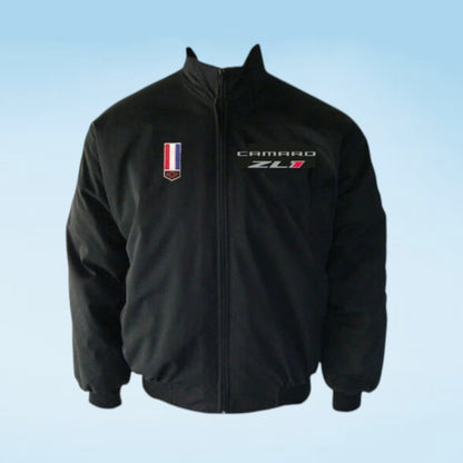 A black zip-up jacket featuring a 'CAMARO ZL1' embroidered logo on the left chest and a small vertical tricolor flag patch on the right chest, displayed against a light blue gradient background.