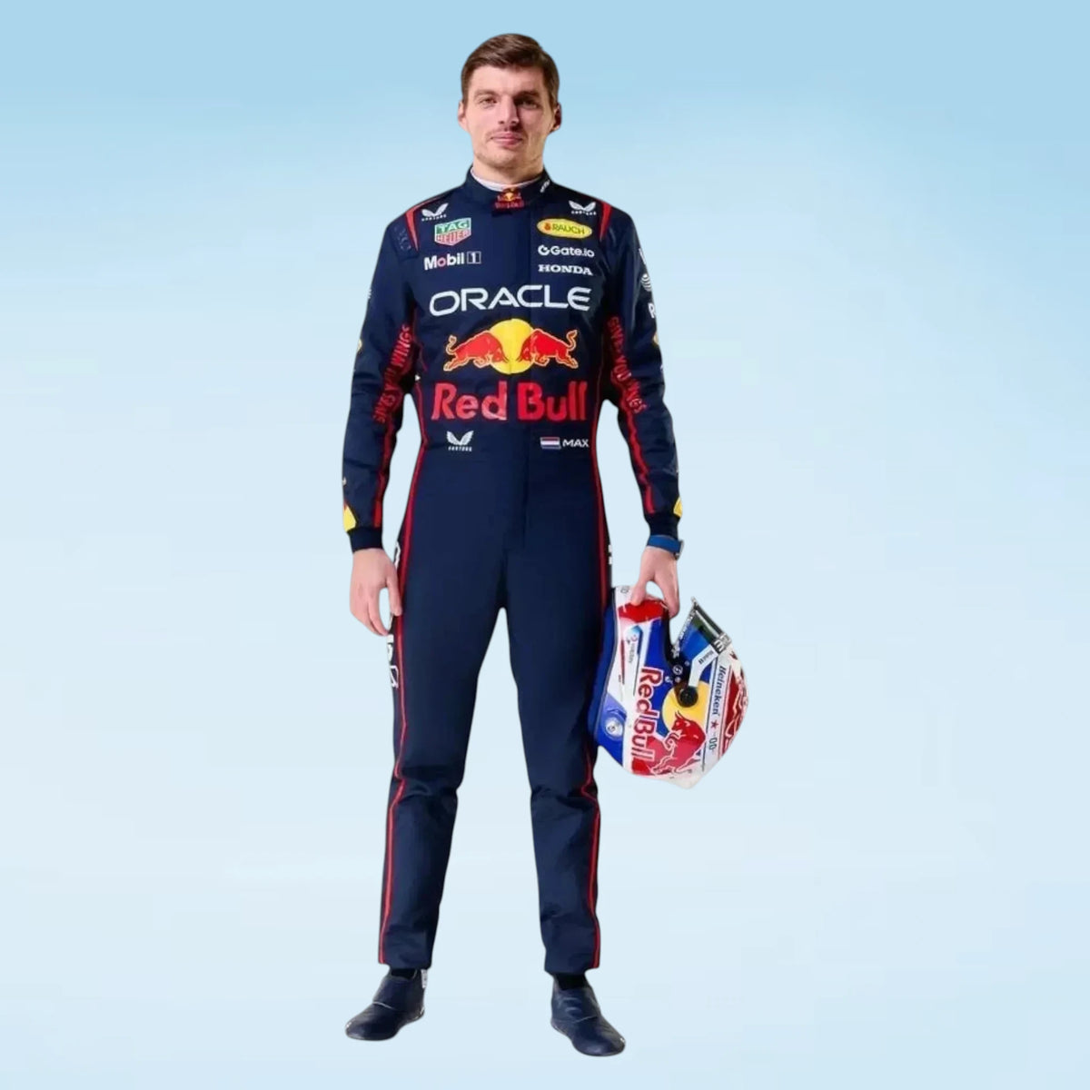 A man stands against a light blue gradient background wearing a dark navy Red Bull Racing suit with red and white sponsor logos, including Oracle, Red Bull, Mobil 1, and Castore. He is holding a matching Red Bull helmet.