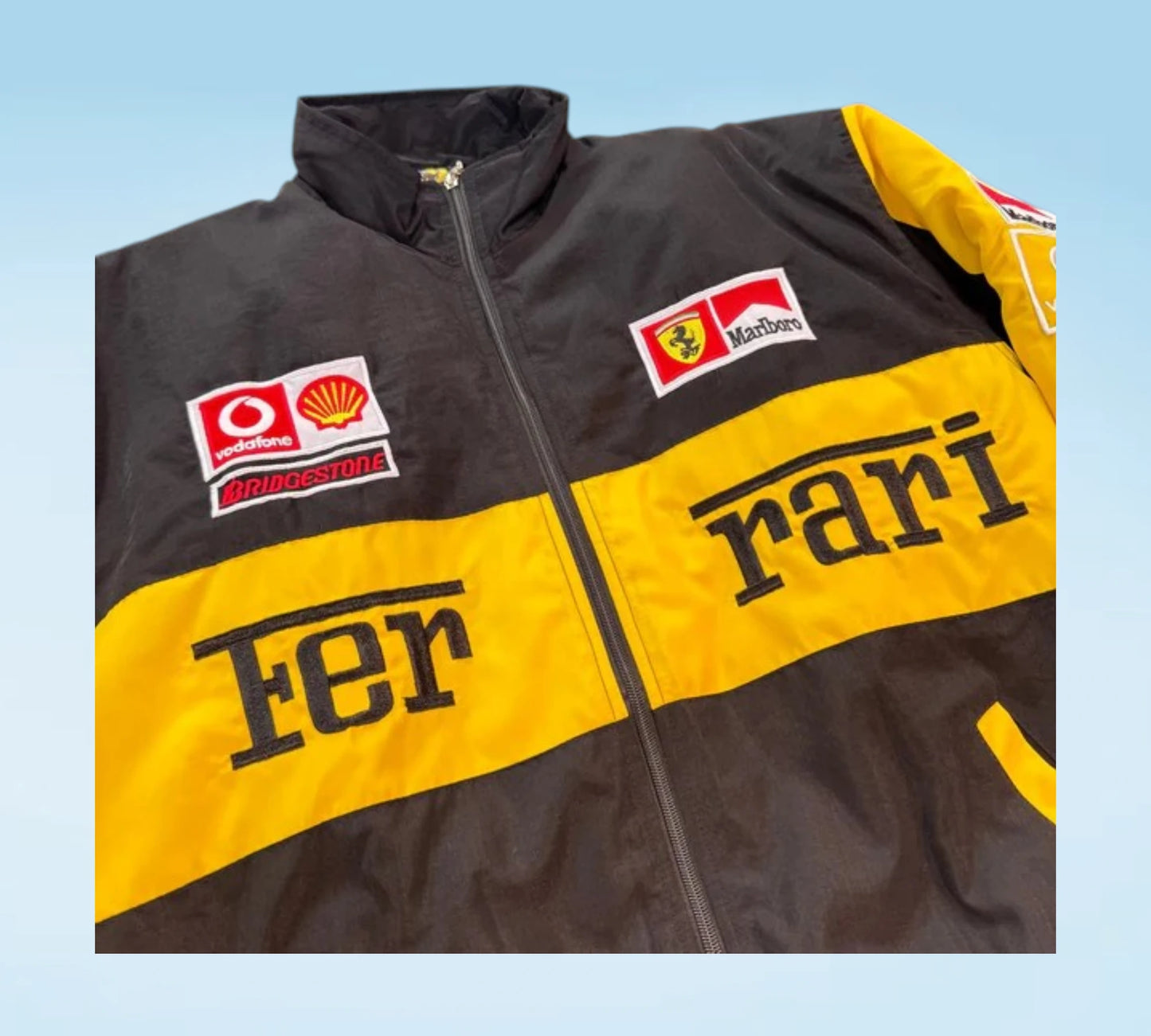 Black and yellow jacket with Ferrari branding on a light blue background