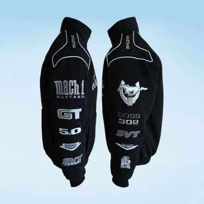 Two black Mustang track jackets shown from the back, featuring white and silver graphics including 'Mach 1 Mustang', 'GT 5.0', 'BOSS 302', and 'SVT' on a light blue gradient background.