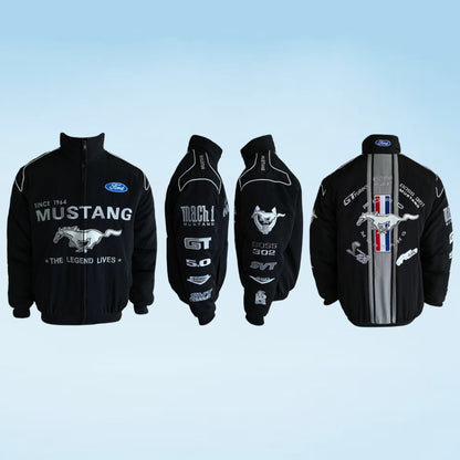 A black Ford Mustang racing jacket shown from four angles (front, back, and three sleeve views) on a light blue gradient background. The jacket features white and silver graphics, including the Ford logo, 'MUSTANG' text, and a large galloping horse graphic on the back.