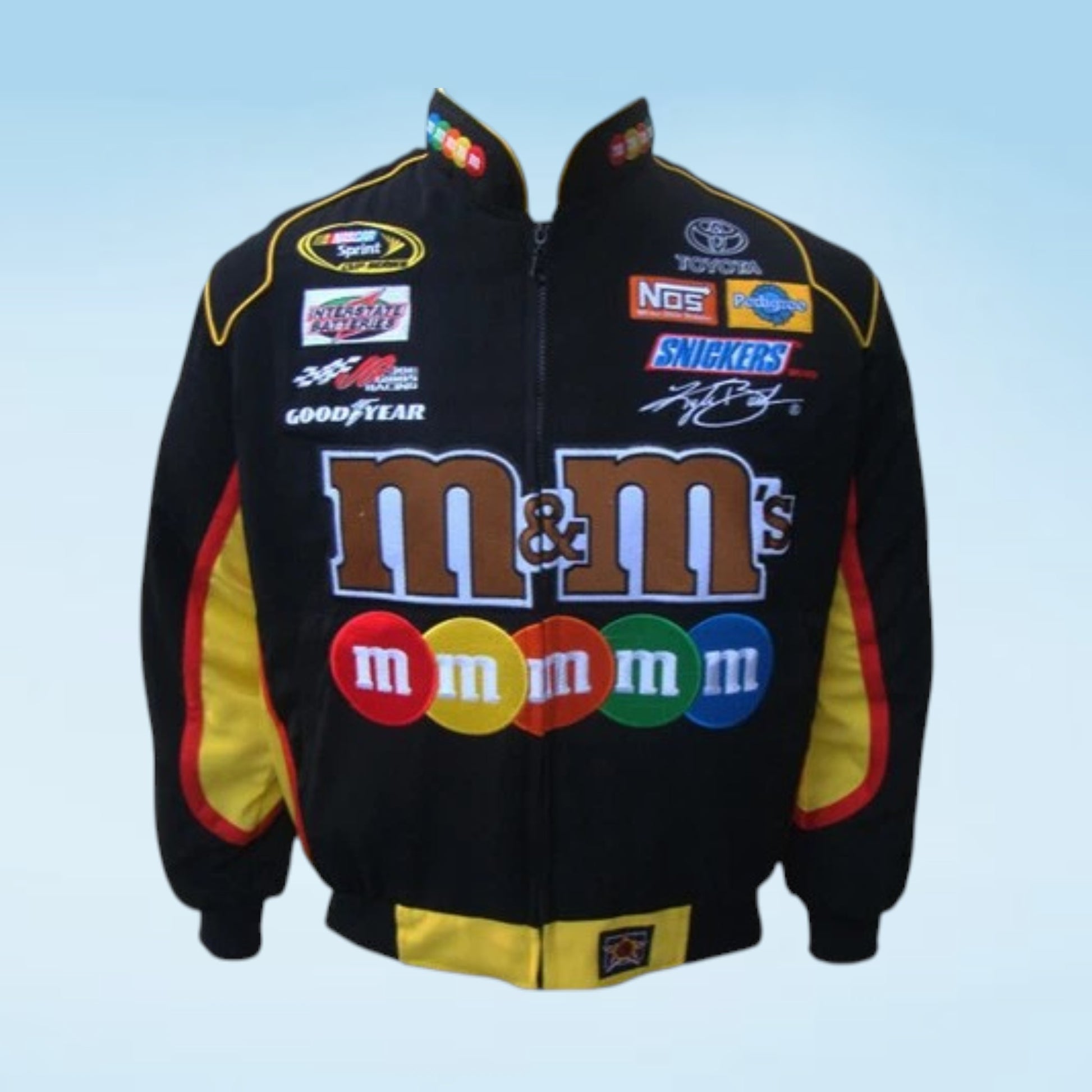 A black zip-up racing jacket featuring the large 'm&m's' logo across the front, with additional sponsor logos including Toyota, NRG, and Goodyear, and yellow and red side panels.