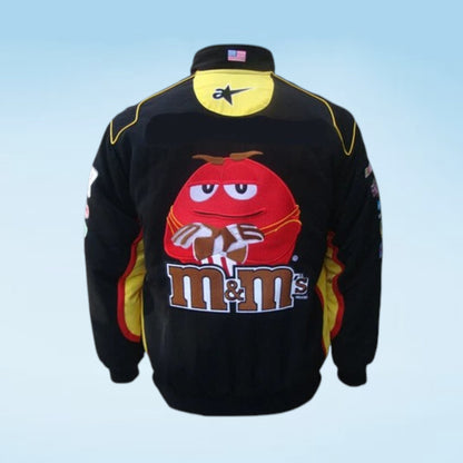 A black racing-style jacket featuring a large red M&M's character graphic and the 'm&m's' logo on the back, with yellow and red side panels and a yellow neck label.