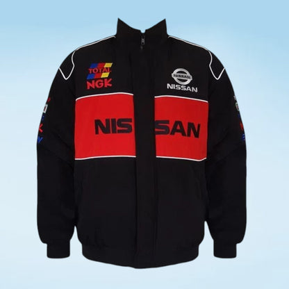A black zip-up racing jacket with bold red chest panels and white piping, featuring visible Nissan and Total NGK logos on the front against a light blue gradient background.